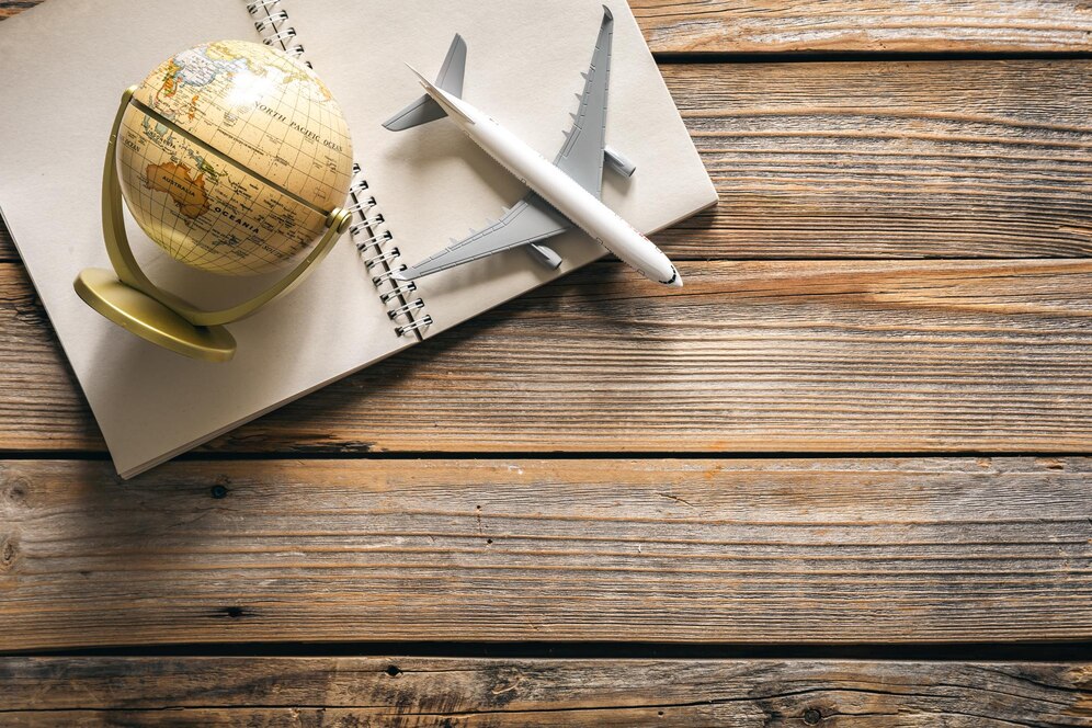 earth globe airplane model notepad wooden background top view_169016 35233